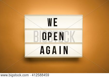 Lightbox with text we open again. Concept of the end of pandemia.
