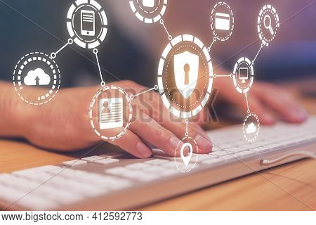 Information And Network Protection With Hologram Cyber Secutrity Icons And Man Hands With Keyboard. 