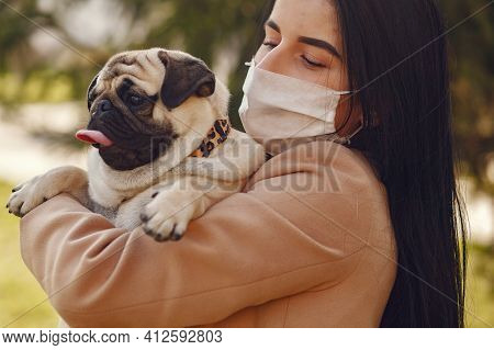 Brunette In A Mask Walks With Pug