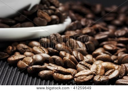 เมล็ดกาแฟที่กระจายอยู่บนพื้นสีดำที่ grooved