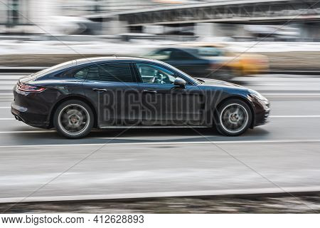 Moscow , Russia - March 3, 2021: Porsche Panamera Fast Moving On City Street. Side View Of Luxury Bl