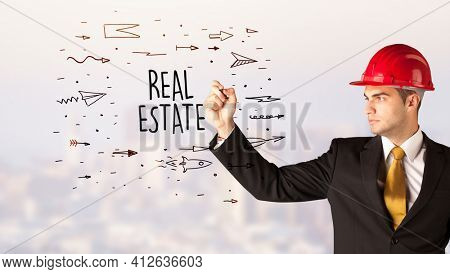 Young businessman with helmet drawing sale sign