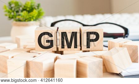 Businesswoman Hand Holding Gmp Word With Wooden Cube Block. Mergers And Acquisitions, Information, C