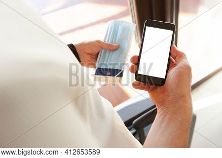 The man holding the mobile phone with blank screen as a mockup for digital vaccination certificate 