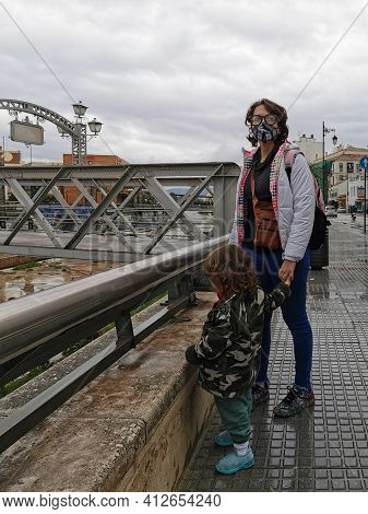 Málaga, Spain - February 21, 2021: View Of Mother And Child On  The Streets And Buildings Of Soho In