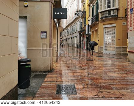 Málaga, Spain - February 21, 2021: View Of Person Using Umbrella On  The Streets Of Soho In Málaga I