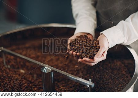 Coffee Cooling In Roaster Machine At Coffee Roasting Process. Young Woman Worker Hold Roasted Brown 
