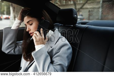 Businesswoman Travelling To Office In A Car Sitting On Backseat And Talking On Cellphone. Businesswo