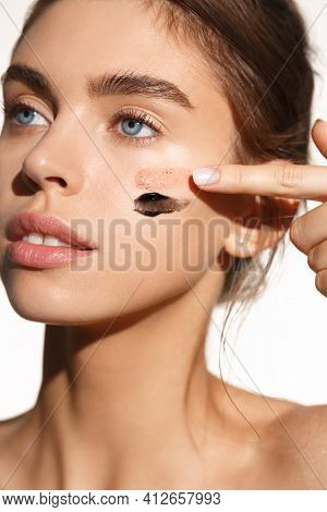 Skincare And Dermatology. Young Woman Apply Two Types Of Facial Cream Masks On Skin, Using Beauty Pr