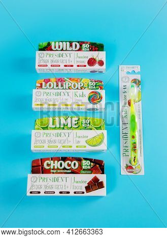 Moscow, Russia - 9th Matra 2021: Childrens Toothpastes And A Toothbrush On A Blue Background.the Con