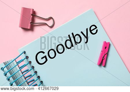 Notebook With Text Goodbye On Pink Background, Flat Lay