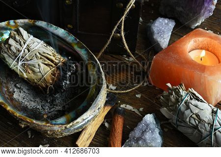 A Close Up Image Of A Burning White Sage Smudge Stick And Healing Crystals.
