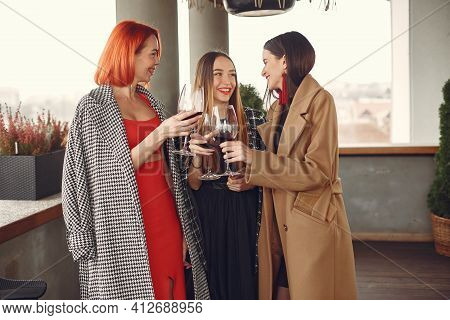 Happy Women Friends Drinking Red Wine Laughing In Teracce