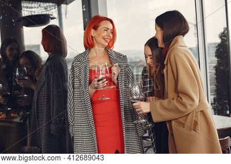 Happy Women Friends Drinking Red Wine Laughing In Teracce