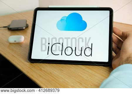 Icloud Logo On The Screen Of Ipad Tablet With Smart Phone Iphone Charging On The Wireless Charger An