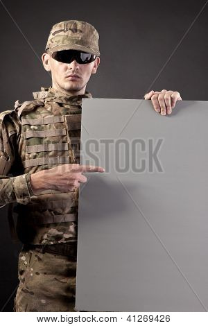 Modern Soldier Is Holding A Poster