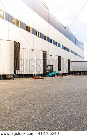 General View To The Loading Gates In The Big Distribution Warehouse With Forklift