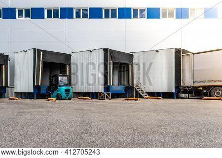 General View To The Loading Gates In The Big Distribution Warehouse With Forklift
