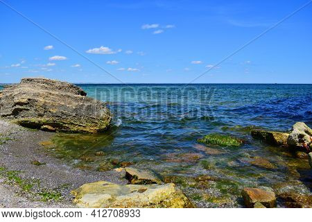 A Picturesque Seascape Overlooking The Blue Sea, Rocks And Stones On A Bright Sunny Day. The Waves B