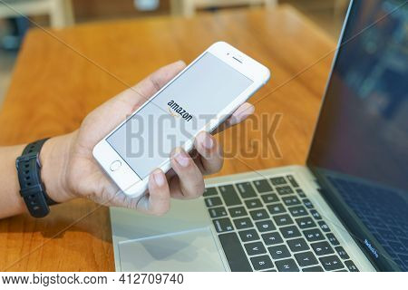 Chiang Mai, Thailand - Dec. 27,2020: Man Holding Iphone 8plus With Amazon Apps. Amazon Is An America