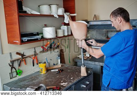 Prosthetist Man Making Prosthetic Leg While Working In Laboratory.