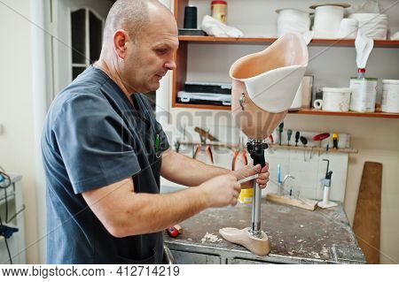 Prosthetist Man Making Prosthetic Leg While Working In Laboratory.