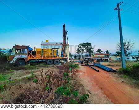 Closeup Of Borewell Drilling Lorry Or Vehicles With Tools, Pipe, Machine And Working Labour And Puja