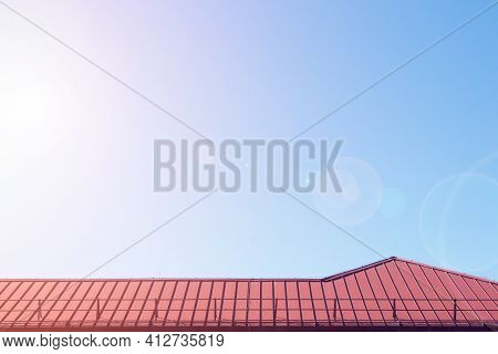 Red Metalic Roof Of Comercial Building. Summer. Lens Flare Effect