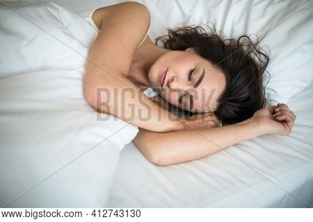 Beautiful young woman sleeping on bed at bedroom