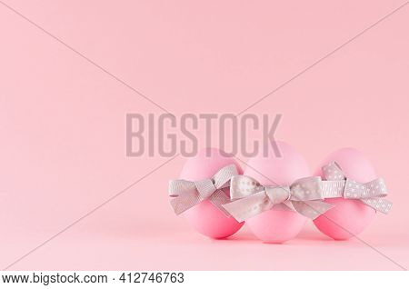Cute And Naivety Easter Background With Pink Eggs Group With Grey Bows On Pastel Pink Backdrop.