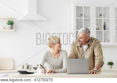 Smiling Senior Couple Spouses Use Laptop, Calculator, New Technology Paying Banking Bills Online