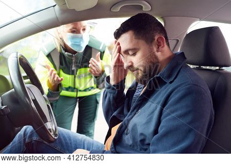 Female Paramedic Helping Male Driver With Whiplash Neck Injury Involved In Road Traffic Accident