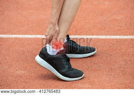 Close Up Of Runner Woman Holding Her Ankle, Suffering From Ankle Pain After Running. Conceptual Of I