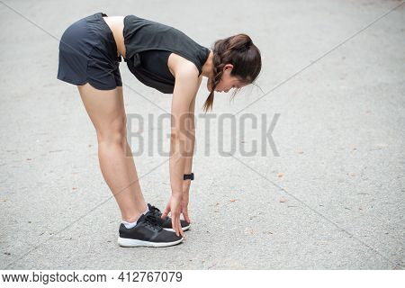 Side Portrait Of Runner Woman Doing Stretching And Warming Up Her Legs Before Running. The Benifit O