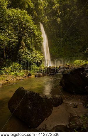 Waterfall Landscape. Beautiful Hidden Waterfall In Tropical Rainforest. Foreground With Big Stones. 