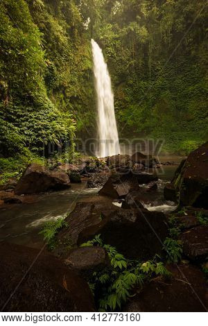 Waterfall Landscape. Beautiful Hidden Waterfall In Tropical Rainforest. Foreground With Big Stones. 