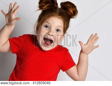 Child Screams Loudly. Stylish Little Girl With Freckles And Red Hair Screams With Her Mouth Wide Ope