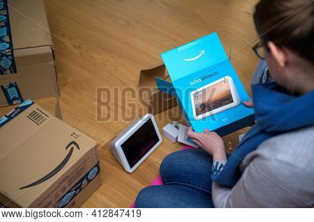 Overhead View Of Young Woman Unboxing Amazon Alexa Smart Speaker
