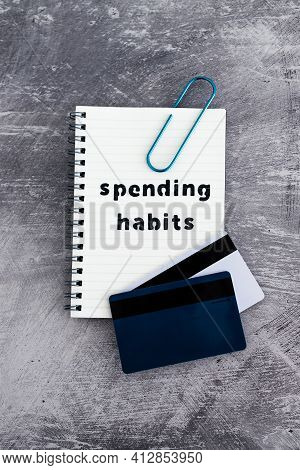 Spending Habits Text On Notepad With Payment Cards Next To It, Money And Consumer Behaviour Conceptu