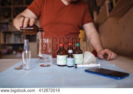 A Middle Aged Man Reading Receipt From Mobile Phone And Doing Hand Sanitizer At Home