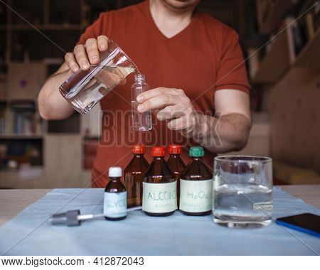 A Middle Aged Man Reading Receipt From Mobile Phone And Doing Hand Sanitizer At Home