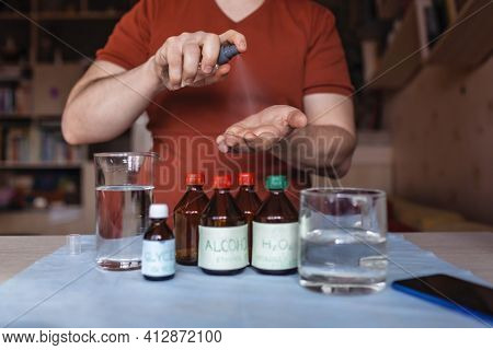 A Middle Aged Man Reading Receipt From Mobile Phone And Doing Hand Sanitizer At Home