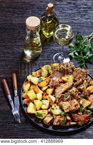 Conejo Al Ajillo, Braised Rabbit With Potatoes, Garlic, White Wine, Salt, And Olive Oil On A Black P