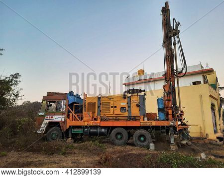 Closeup Of Borewell Drilling Lorry Or Vehicles With Tools, Pipe, Machine And Working Labour And Puja