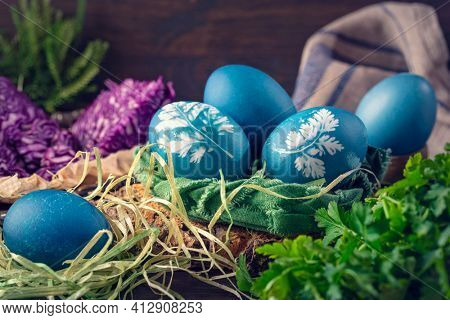 Natural dyed easter eggs on a wooden background. Colored with red cabbage. For greenish blue red cabbage with soda can be used.