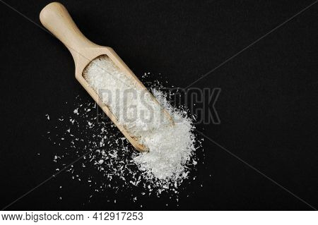 Coconut Shavings. Wooden Scoop Spoon With Coconut Shavings On Black Background. Copy Space. Shredded