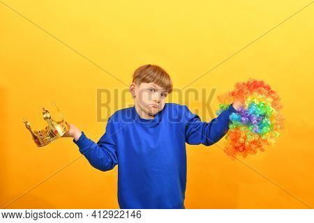 The Boy Holds A Clown Wig In One Hand And A Golden Crown In The Other. The Choice Between Control An
