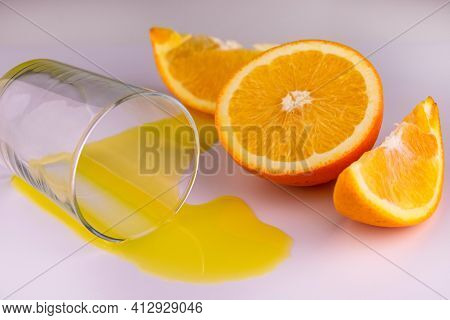 A Glass With A Spilled Orange Forefoot On A White Background.