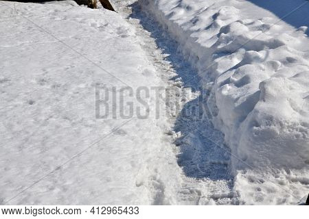 A Paved Footpath From A Man's Feet In A Winter Snowy Landscape