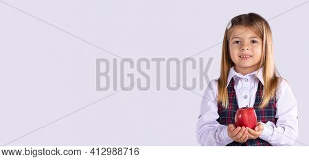 Banner, Long Format. A Portrait Of A Schoolgirl Girl In Uniform Looks At The Camera With A Smile And